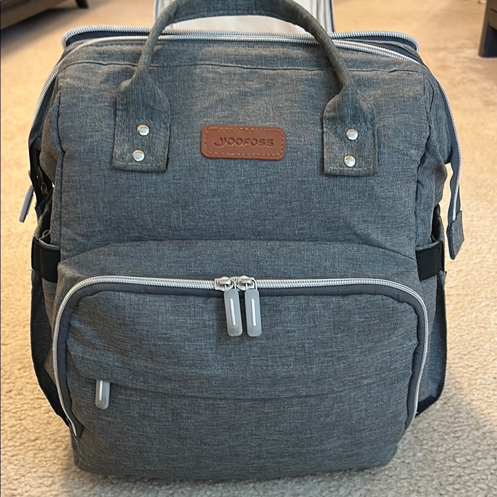 Gray Diaper Backpack With Foldout Bassinet.